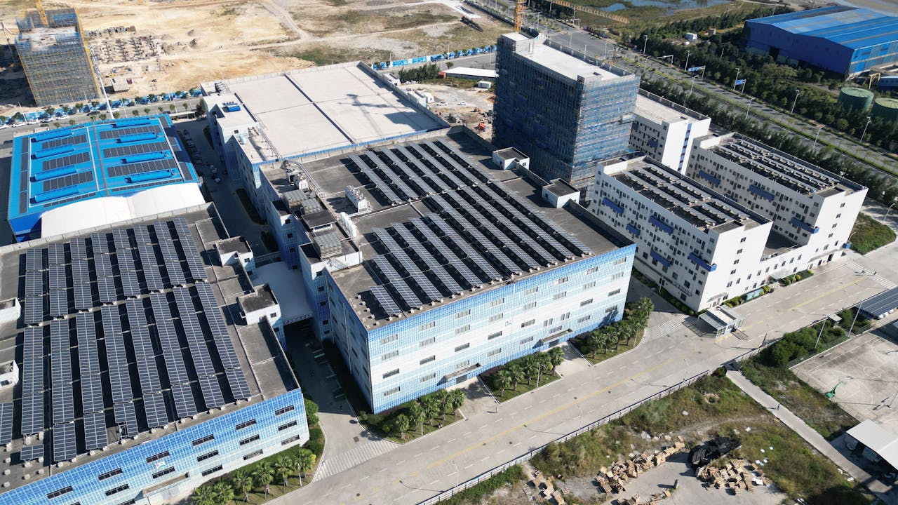 Industrial buildings with solar panels, aerial view showcasing renewable energy.